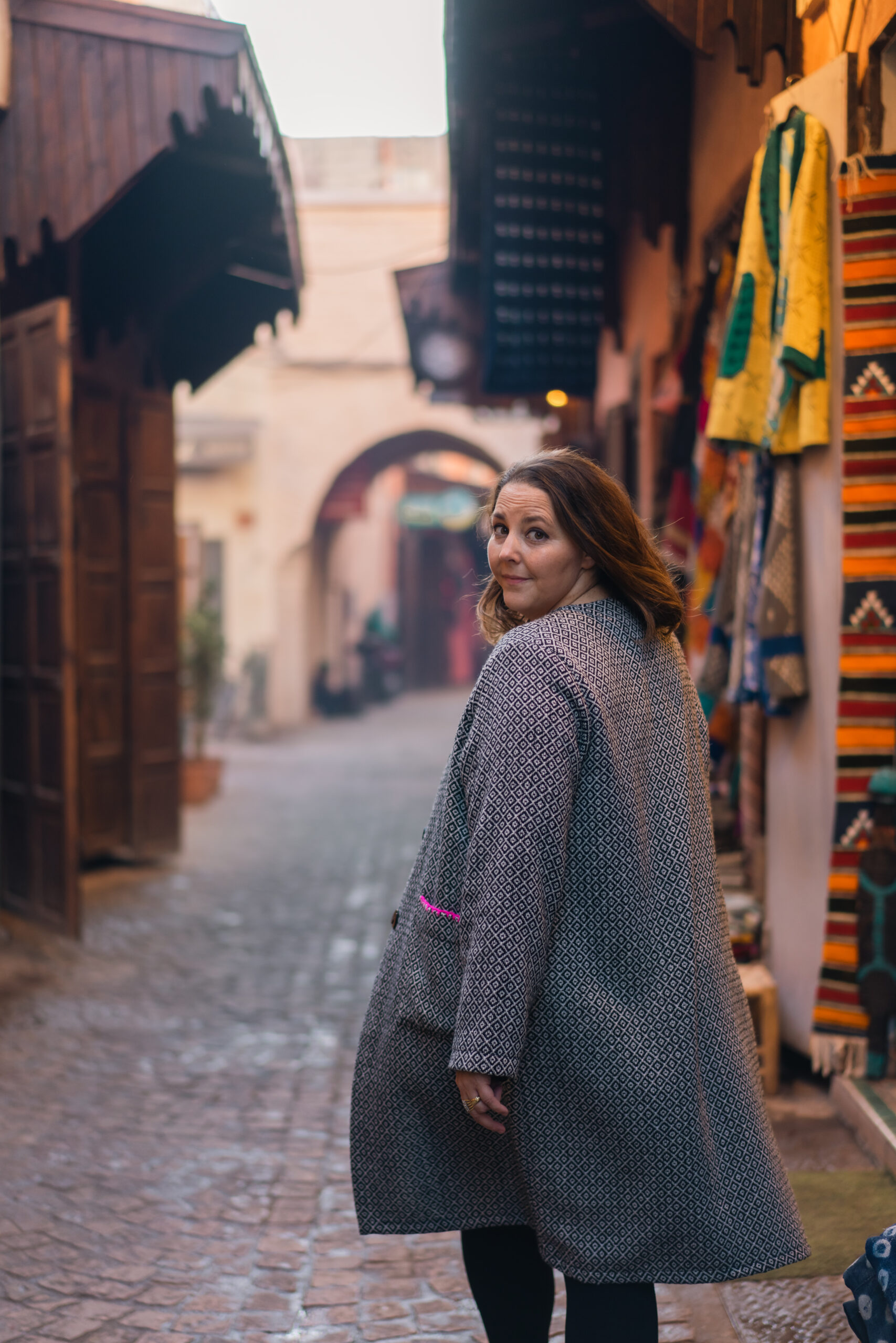 A woman turning to look back in a Marrakech medina street
